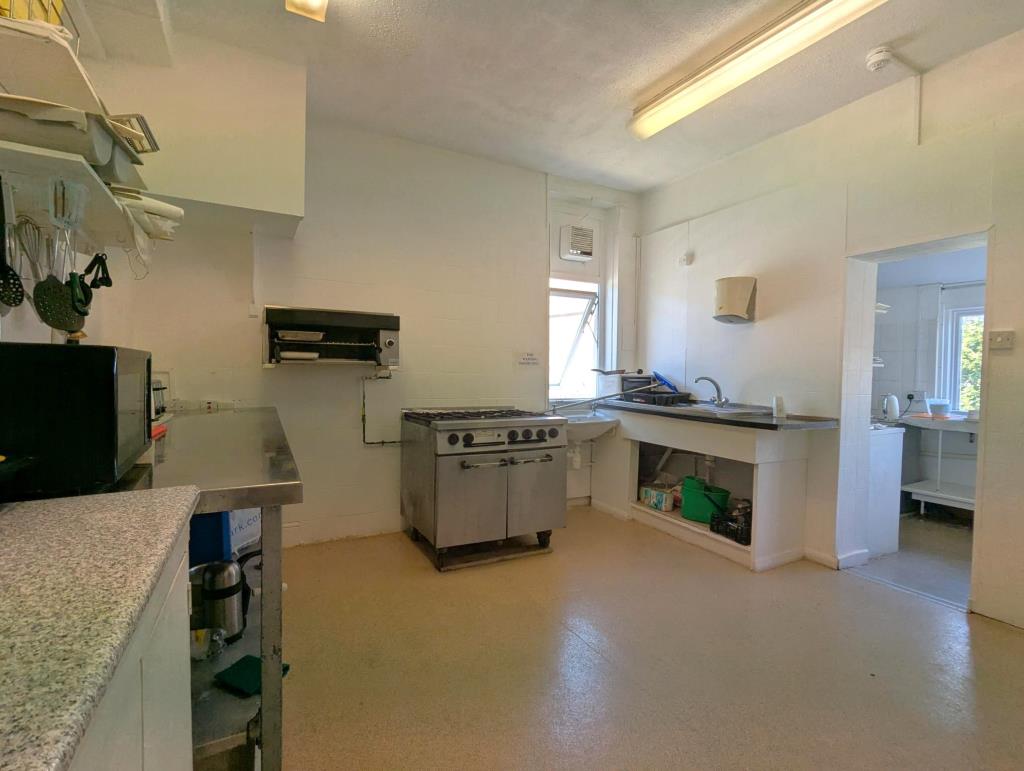 Lot: 37 - FORMER HOTEL PARTIALLY CONVERTED TO AN HMO WITH SCOPE FOR FURTHER CONVERSION - A reverse angle view of the first floor kitchen